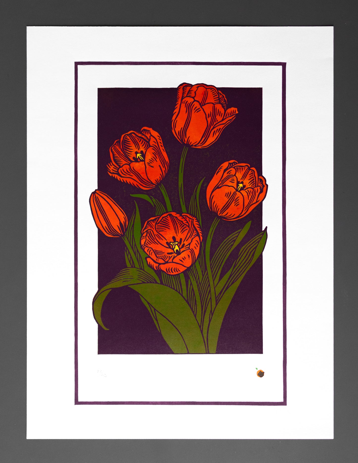 lino print of red tulips on a dark purple background with a white border