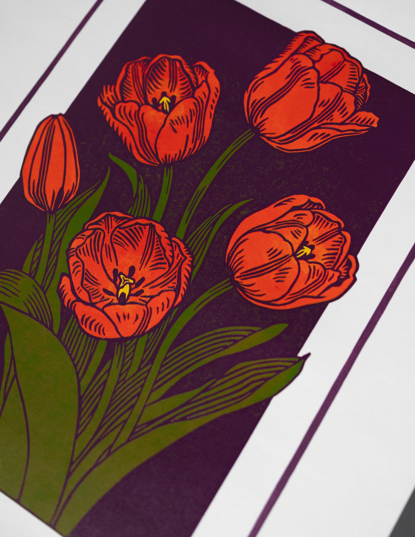 Red tulips linoprint on a purple background with green leaves